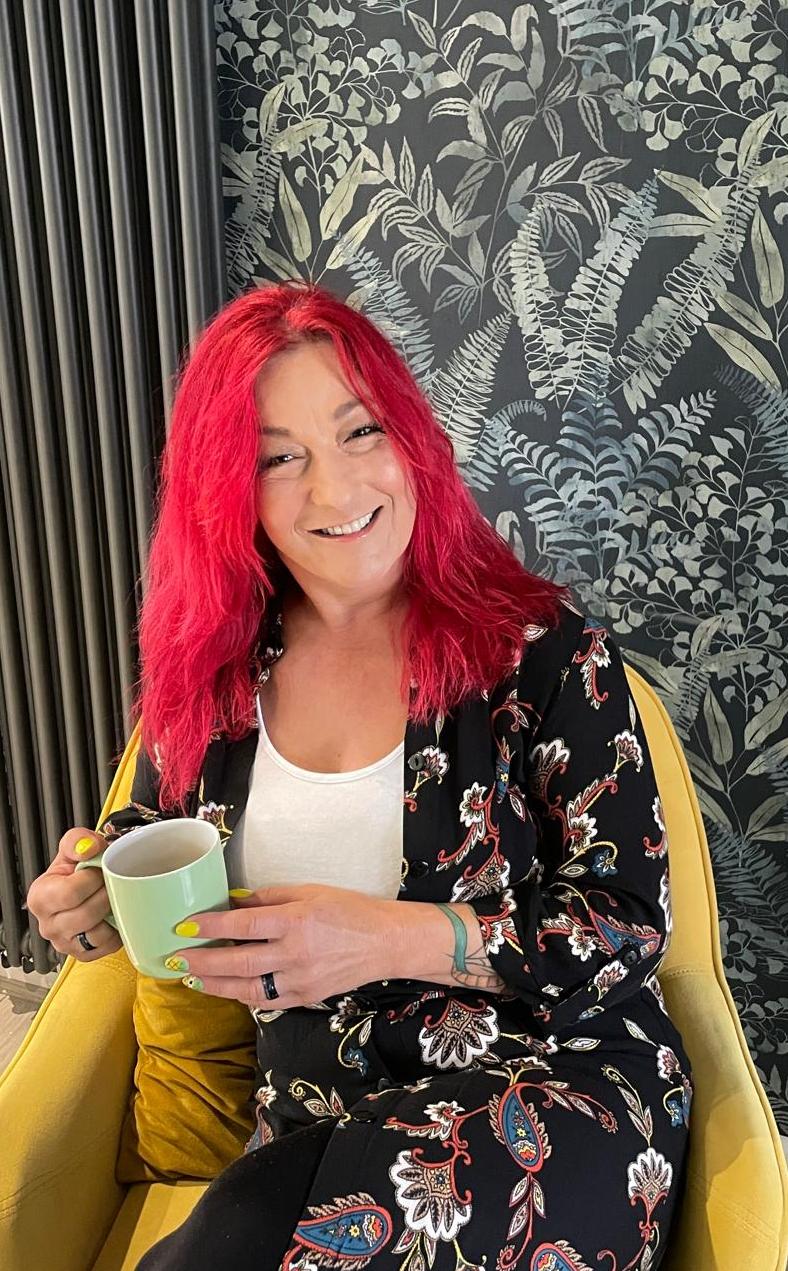 Julie, founder of Clean Leeds, smiling with a cup of tea at home